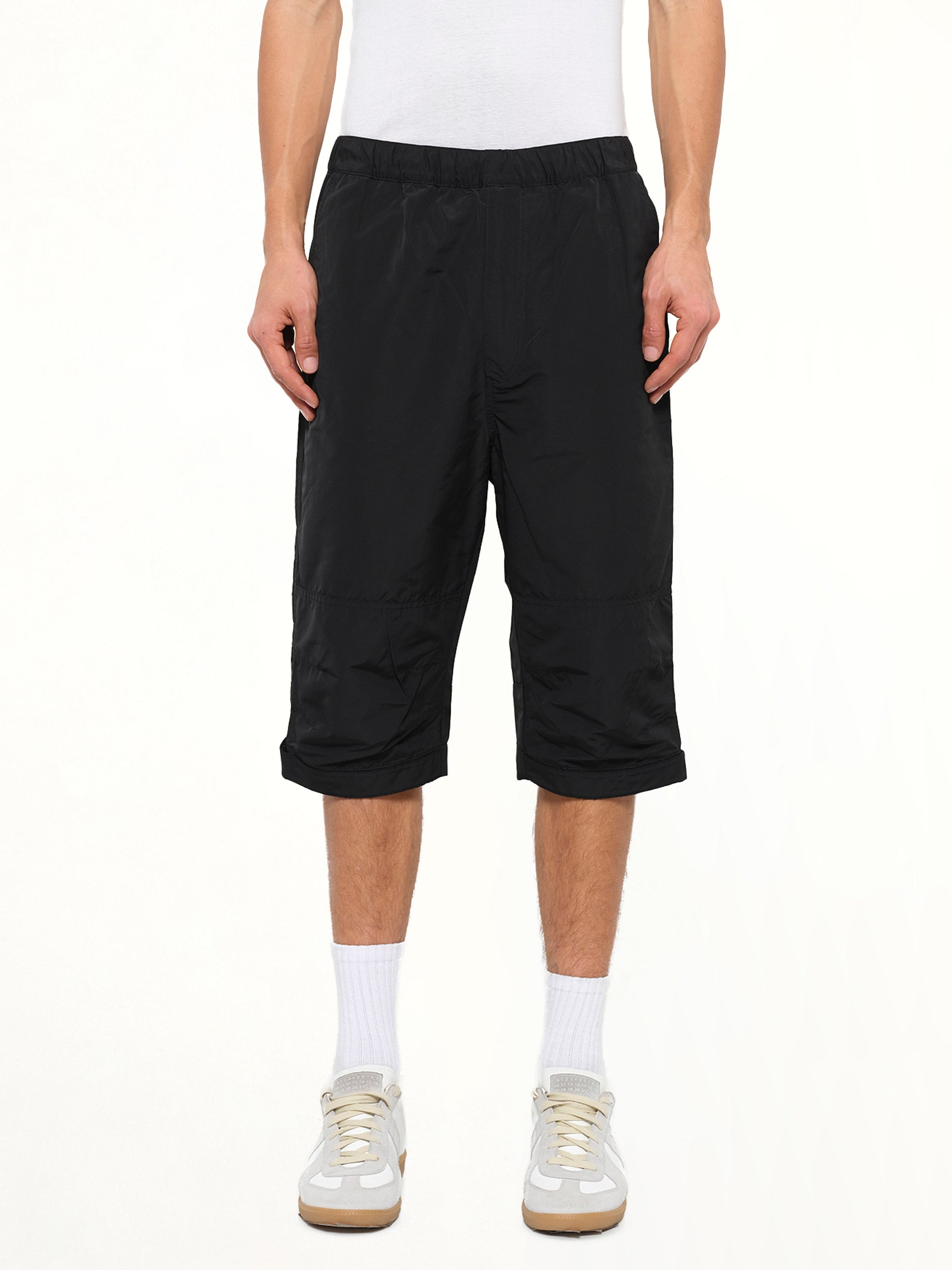 Image of a model wearing Shorts. Product name - Long Stretch Waist Shorts in Black colour by brand - GIVENCHY