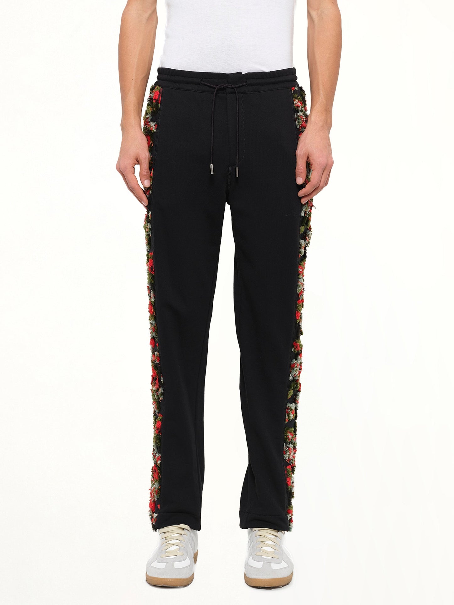 Image of a model wearing Pants. Product name - Loopback Sweatpants in Black colour by brand - ALEXANDER MCQUEEN