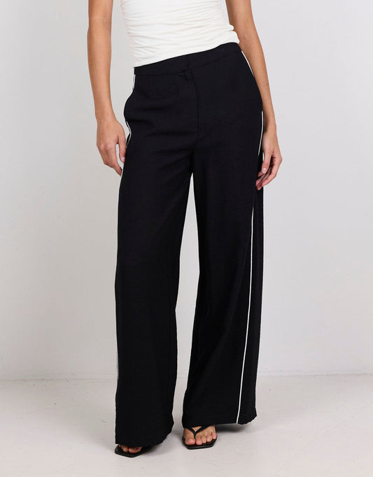 Image of a model wearing Pants. Product name - Exception Piped Side Pants Black in Black colour by brand - Among The Brave