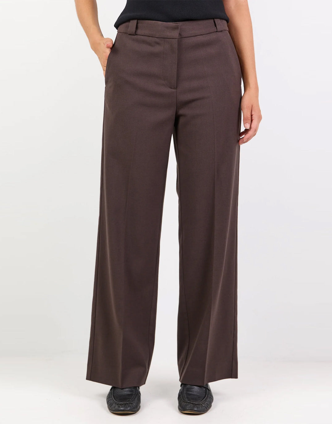 Image of a model wearing Pants. Product name - Jaunty Slant Pocket Wide Leg Pants Dark Chocolate in Dark Chocolate colour by brand - Among The Brave