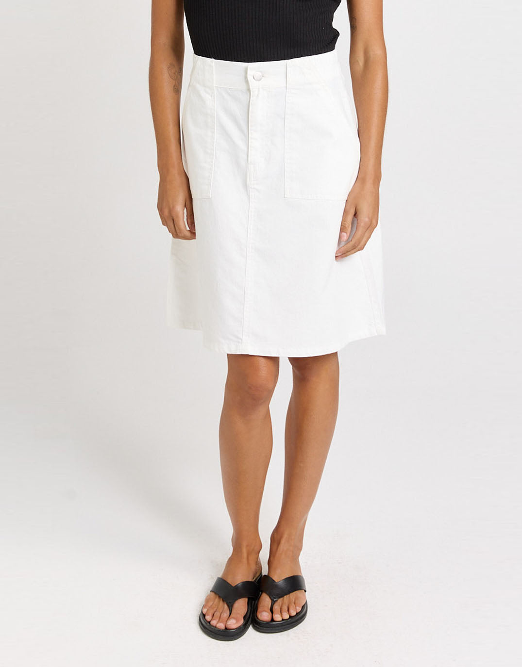 Image of a model wearing Skirts. Product name - Aida Denim Skirt White in White colour by brand - Betty Basics