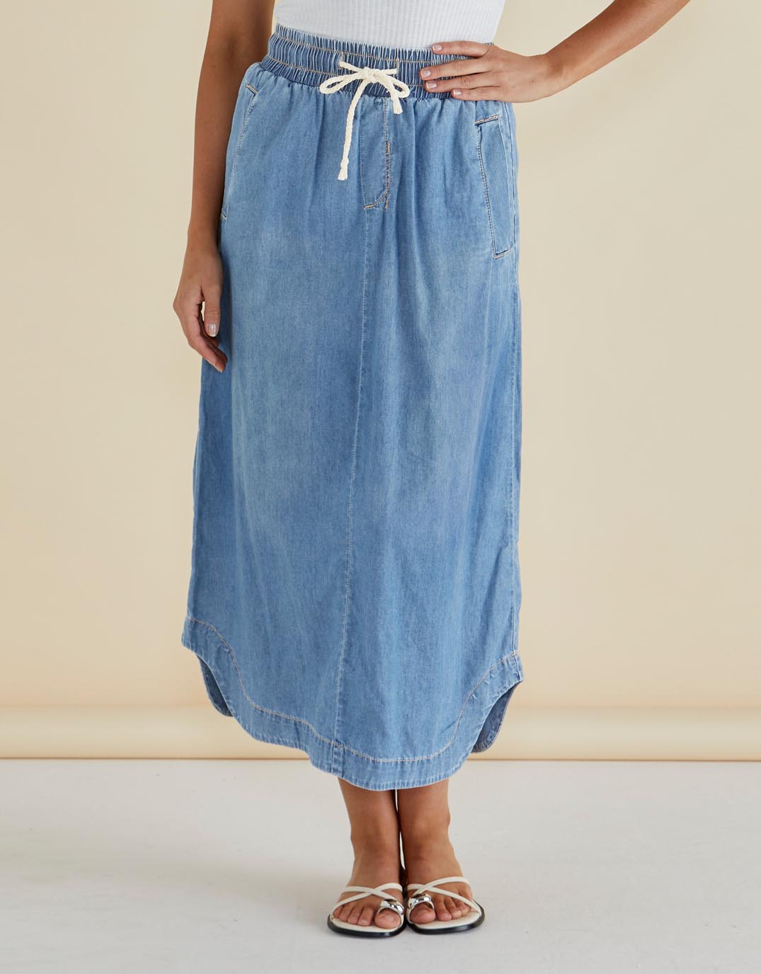 Image of a model wearing Skirts. Productname: Brunch Denim Skirt - in Oasis Blue colour by brand - Betty Basics