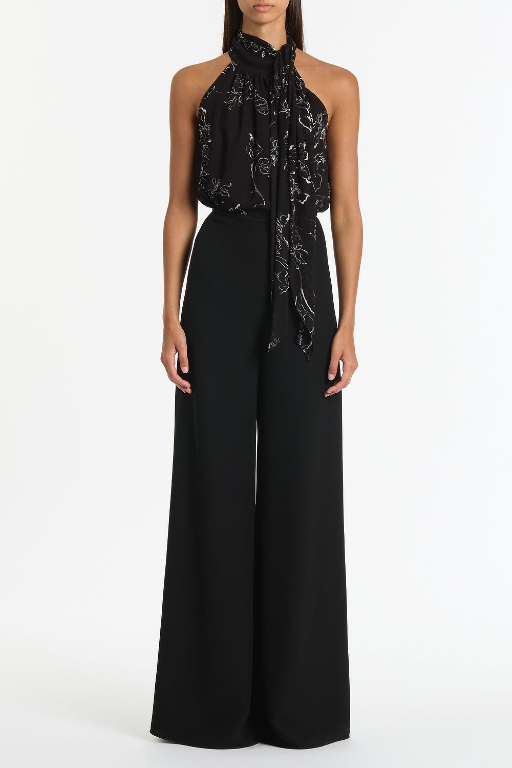 Image of a model wearing Tops. Product name - Black Linear Floral Gathered Halter Top in Black colour by brand - Carla Zampatti