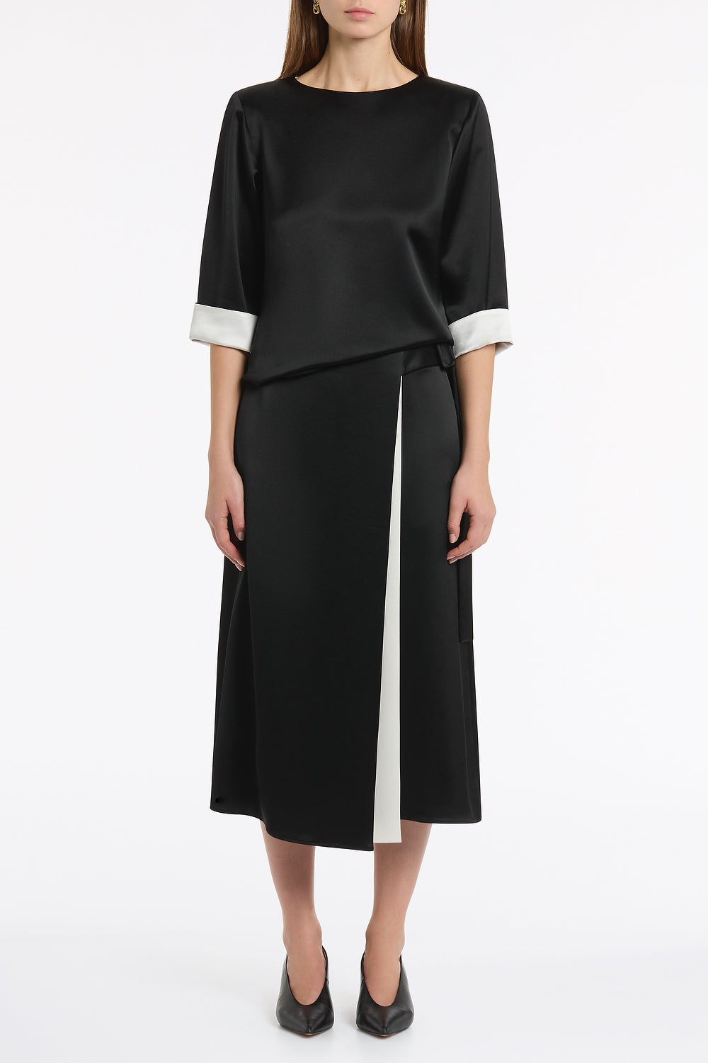 Image of a model wearing Tops. Product name - Black Satin Acetate Relaxed Split Hem Tee in Black colour by brand - Carla Zampatti