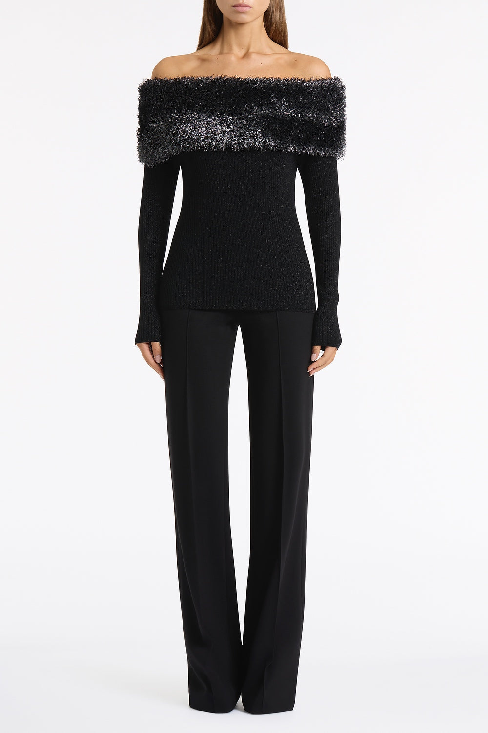 Image of a model wearing Tops. Product name - Black Shimmer Knit Off Shoulder Top in Black colour by brand - Carla Zampatti