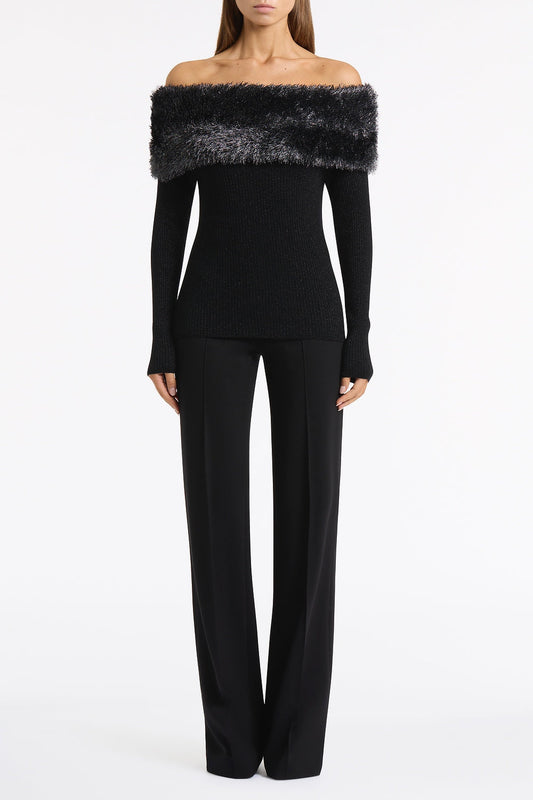 Image of a model wearing Tops. Product name - Black Shimmer Knit Off Shoulder Top in Black colour by brand - Carla Zampatti