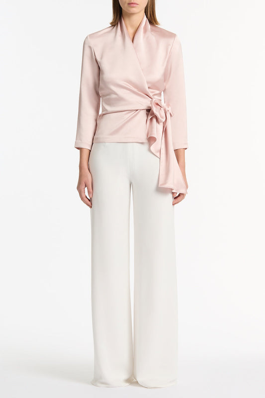 Image of a model wearing Tops. Product name - Blush Lustre Satin Wrap Top in Pink colour by brand - Carla Zampatti