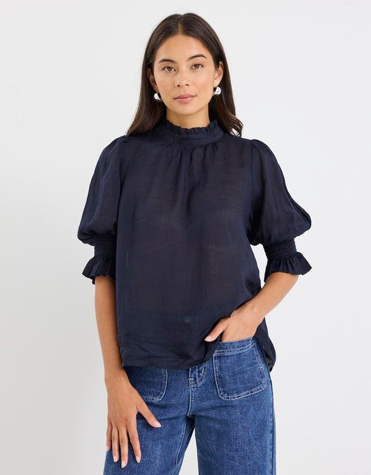 Image of a model wearing Tops. Productname: Verse Sheer High Neck Short Sleeve Top - in Navy colour by brand - By Rosa