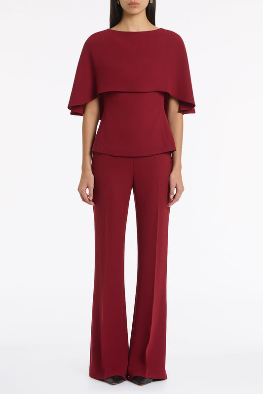 Image of a model wearing Tops. Product name - Cabernet Crepe Cape Top in Red colour by brand - Carla Zampatti