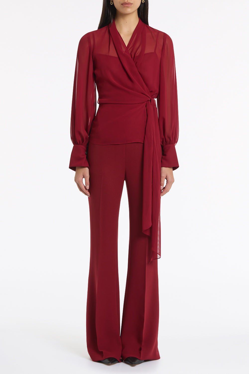 Image of a model wearing Tops. Product name - Cabernet Georgette Long Sleeve Wrap Blouse in Red colour by brand - Carla Zampatti