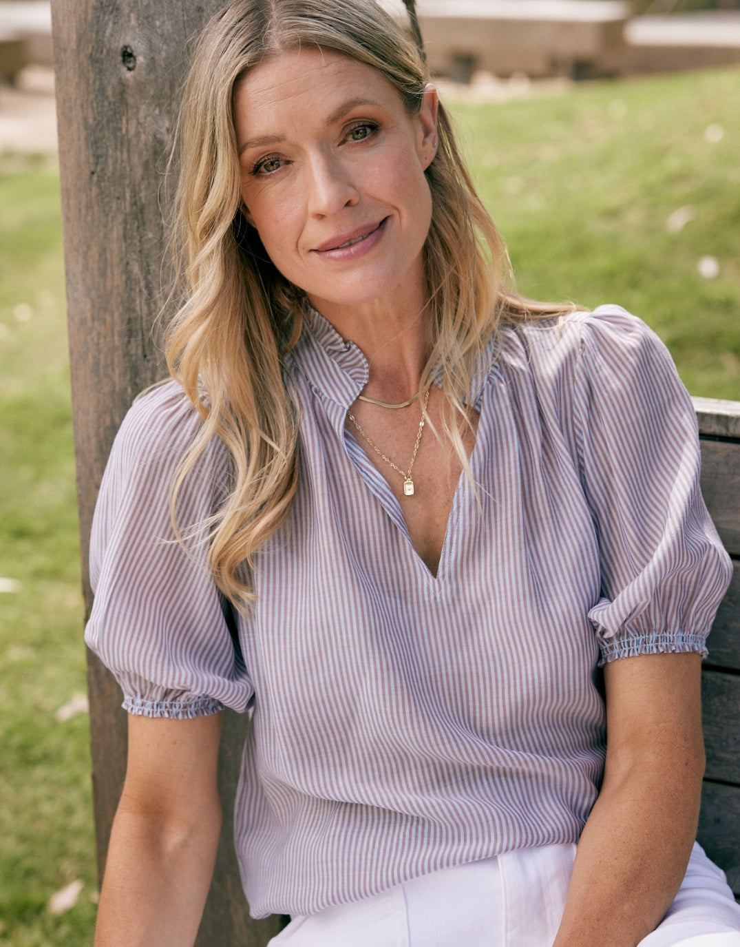 Image of a model wearing Tops. Product name - Camden Ruffle Blouse Blue/Choc Stripe in Blue/Choc Stripe colour by brand - White & Co.