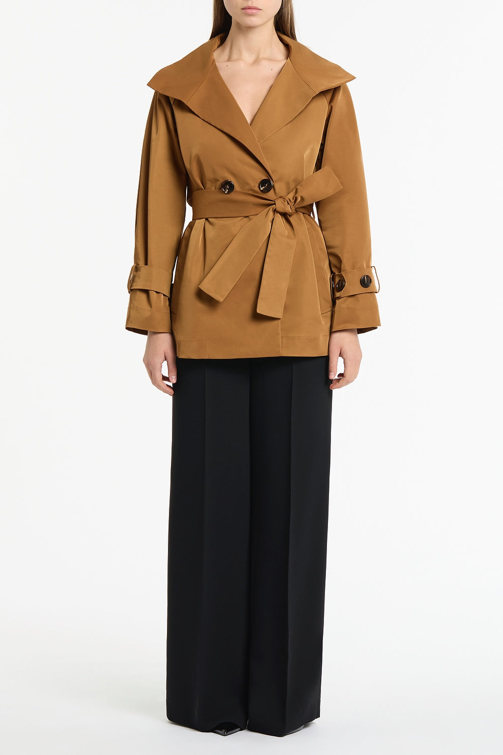 Image of a model wearing Shorts. Product name - Camel Taffeta Twill Short Trench Coat in Brown colour by brand - Carla Zampatti