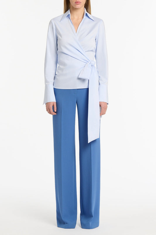 Image of a model wearing Tops. Product name - Chambray Wrap Top in Blue colour by brand - Carla Zampatti