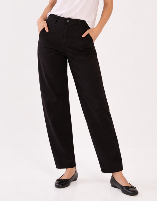 Image of a model wearing Pants. Product name - Barrel Leg Chino Black in Black colour by brand - Betty Basics