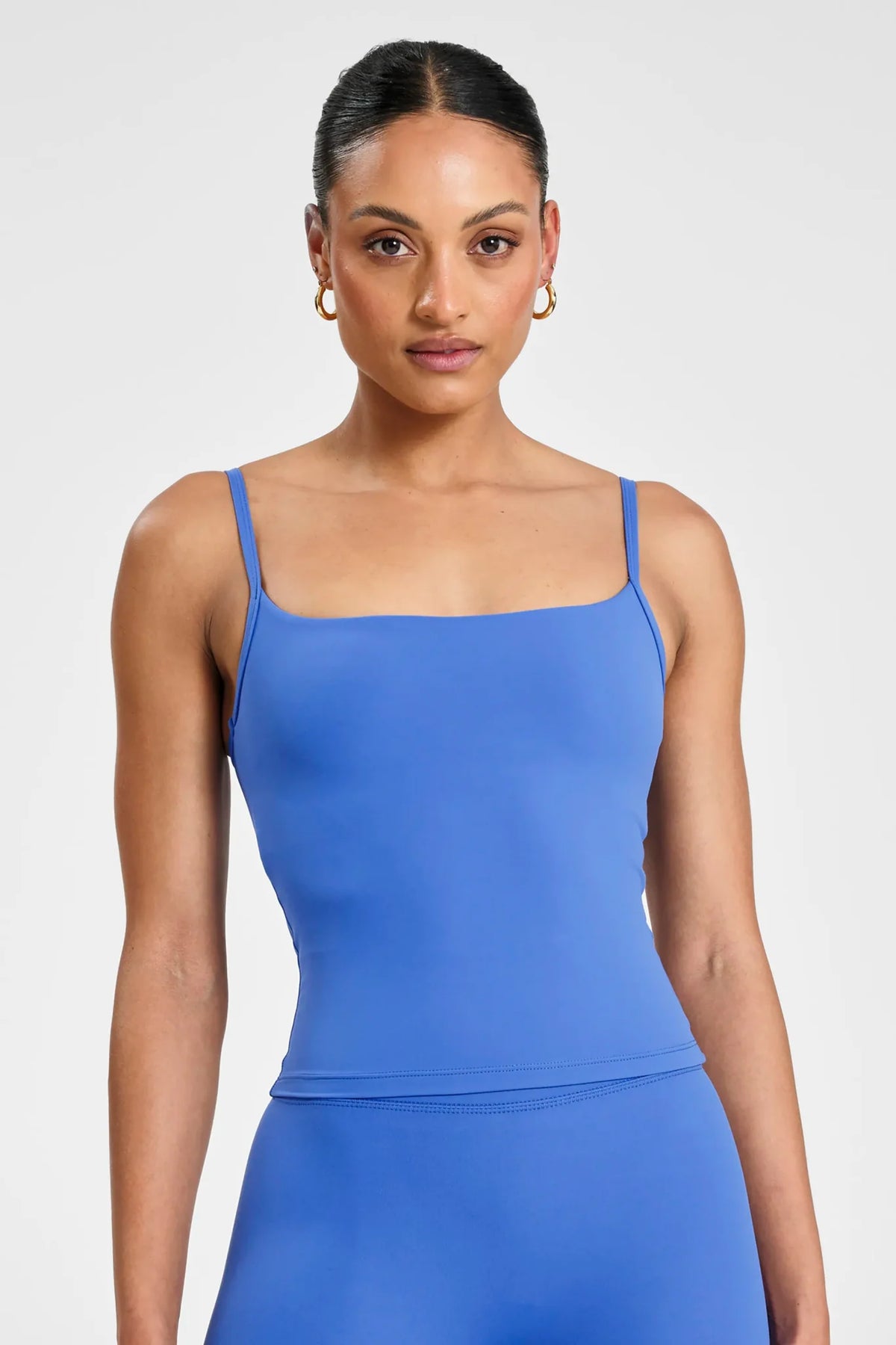 Image of a model wearing Tops. Product name - ALLFENIX CloudCore Sculpt Tank in Blue colour by brand - All Fenix
