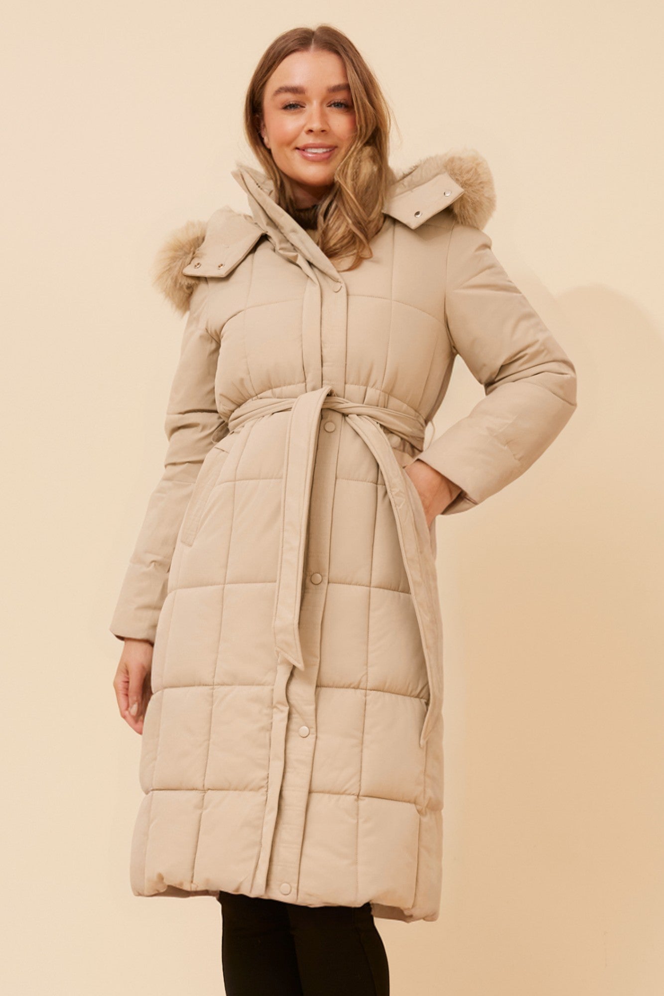 Image of a model wearing Outerwear. Product name - ELVERA SOLID PUFFER COAT in Beige colour by brand - Caroline Morgan Australia