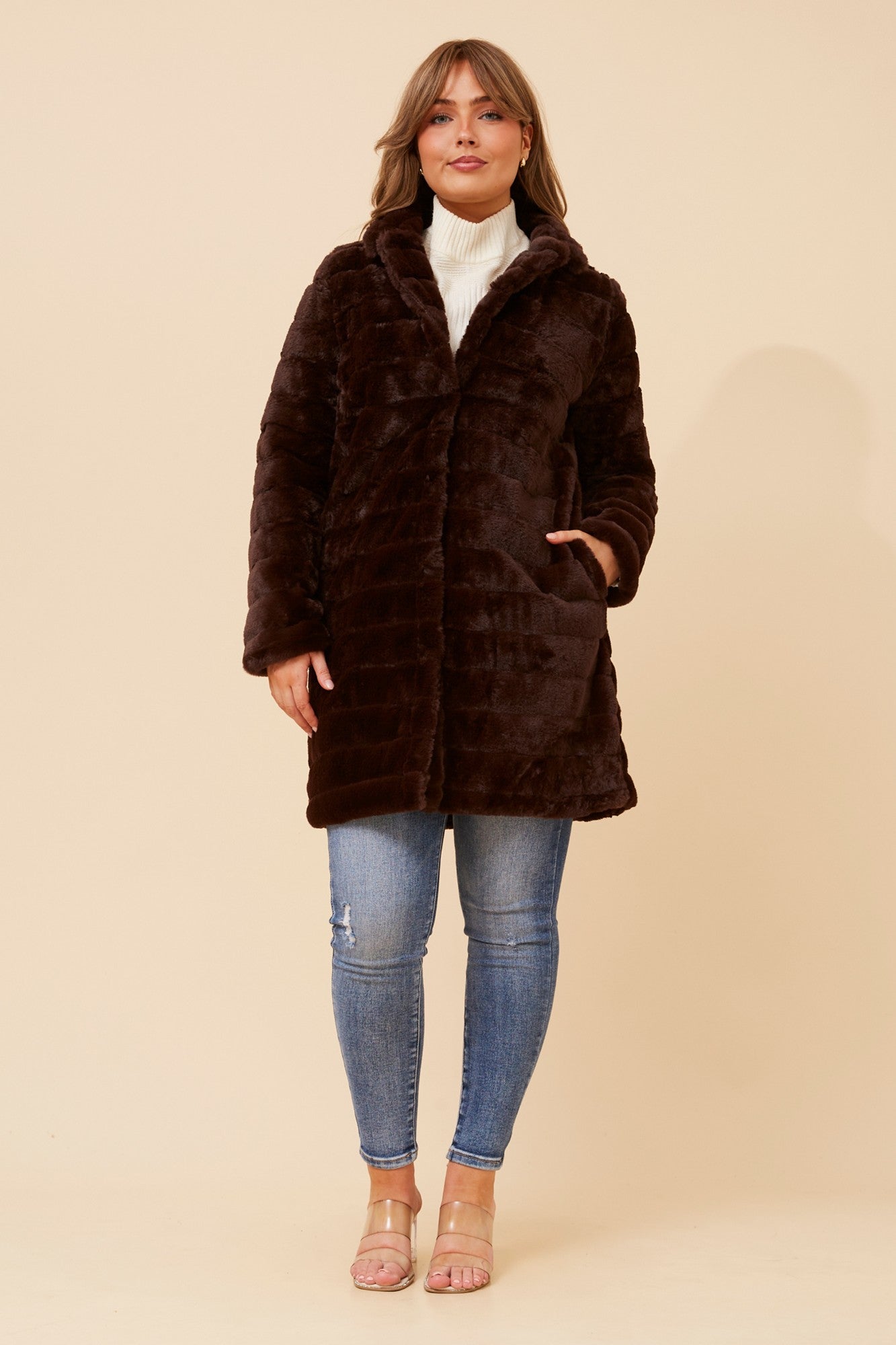 Image of a model wearing Outerwear. Product name - AXELLE FAUX FUR COAT in Beige colour by brand - Caroline Morgan Australia