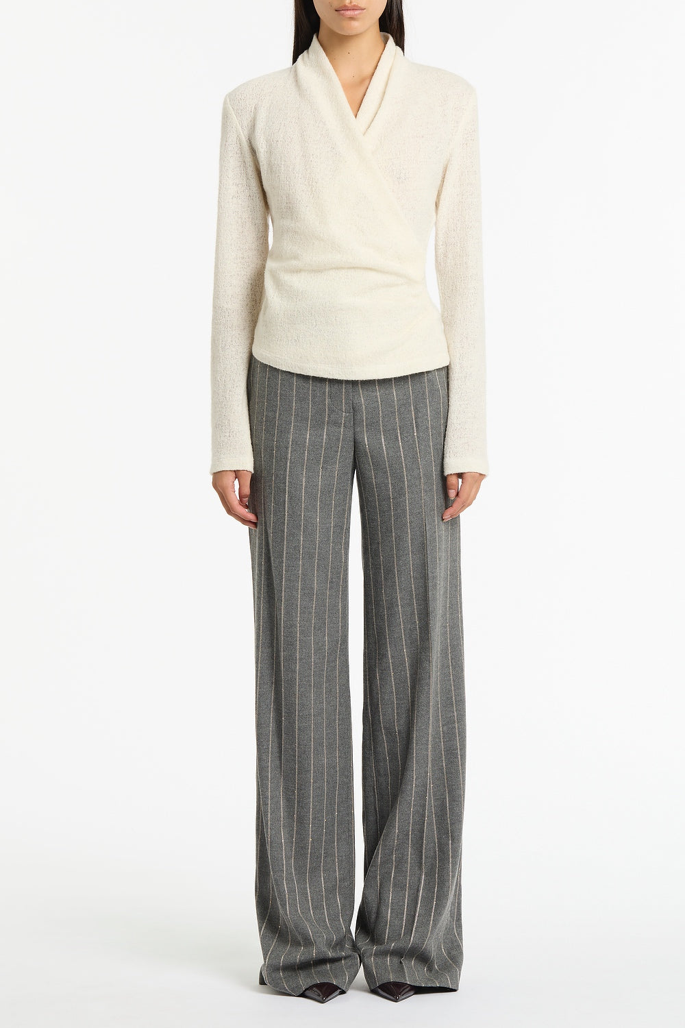 Image of a model wearing Tops. Product name - Crème Looped Knit Shawl Wrap Top in Cream colour by brand - Carla Zampatti