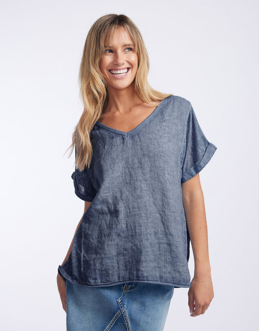 Image of a model wearing Tops. Product name - Calypso Linen Short Sleeve Top Denim in Denim colour by brand - Love from Italy