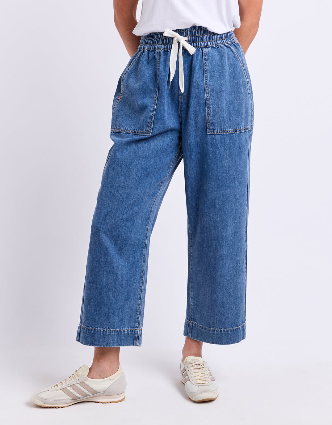 Image of a model wearing Pants. Product name - Greta Slim Leg Pant Blue in Blue colour by brand - Elm