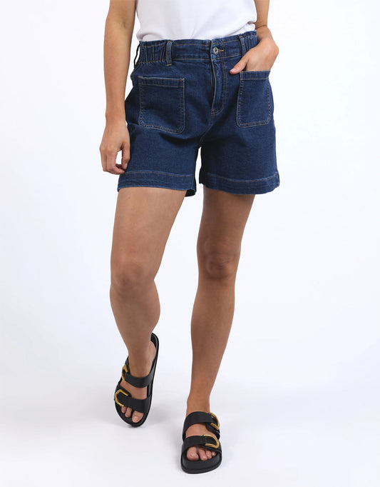 Image of a model wearing Shorts. Productname: Lennox Denim Shorts - in Dark Blue Wash colour by brand - Elm