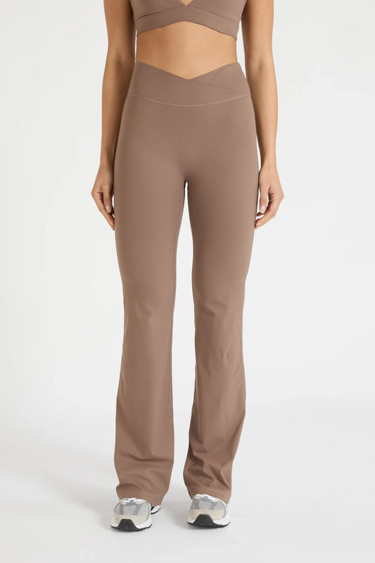 Image of a model wearing Pants. Product name - ALLFENIX CloudCore V-Waist Flared Legging in Latte colour by brand - All Fenix