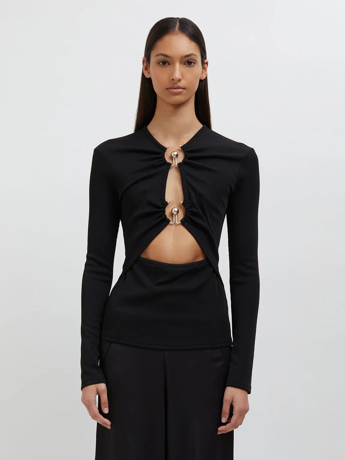 Image of a model wearing Tops. Productname: Christopher Esber Orbit Ruched Long Sleeve Top in Black colour by brand - Christopher Esber