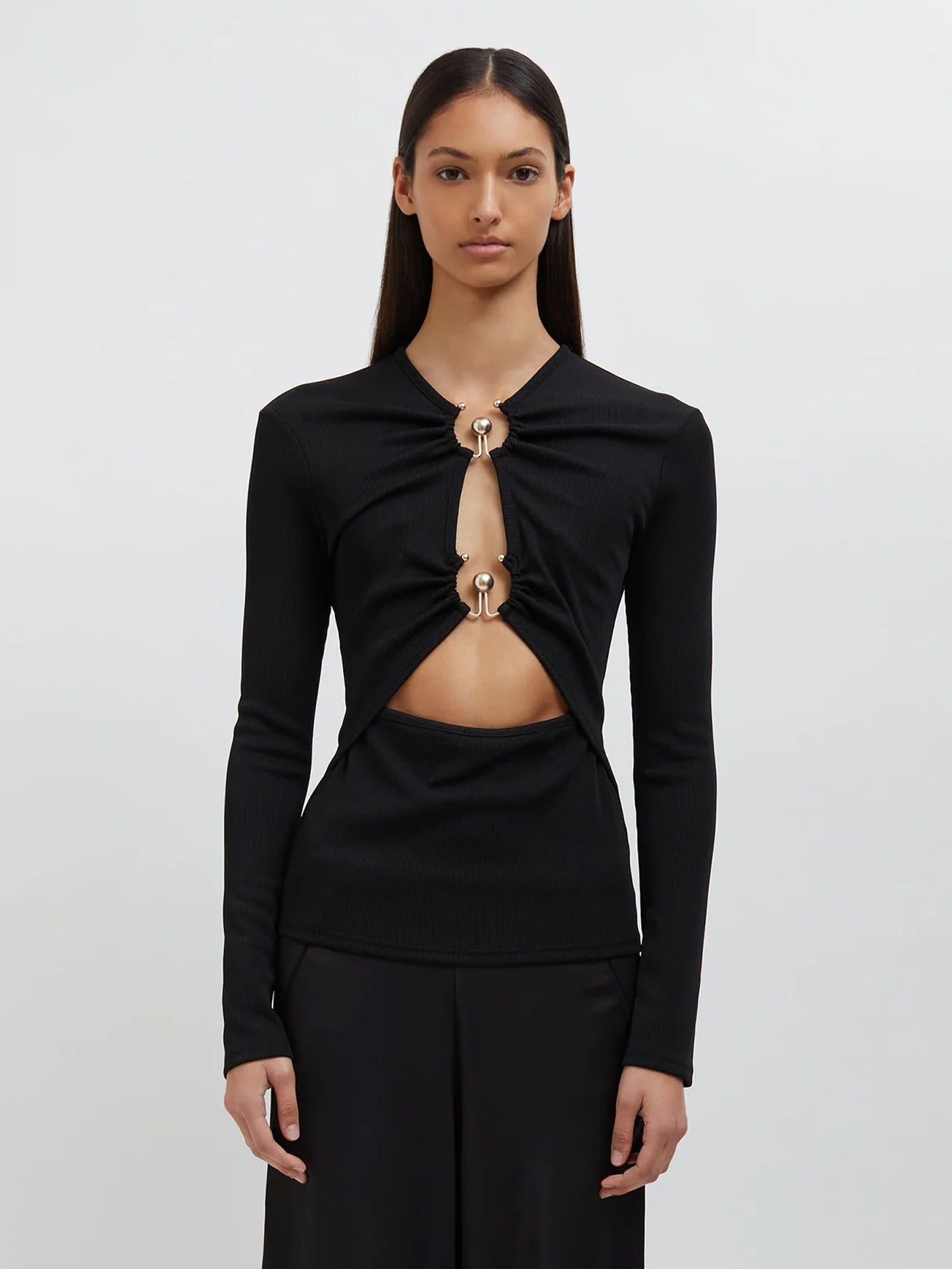 Image of a model wearing Tops. Productname: Christopher Esber Orbit Ruched Long Sleeve Top in Black colour by brand - Christopher Esber