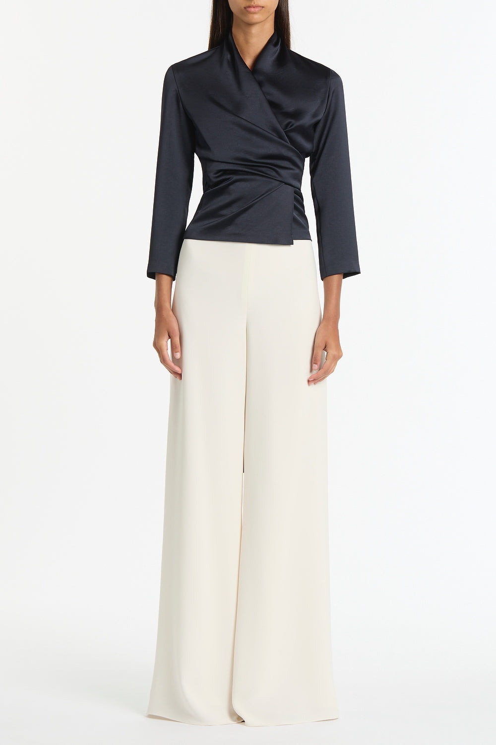 Image of a model wearing Tops. Product name - Ink Satin Wrap Top in Navy colour by brand - Carla Zampatti