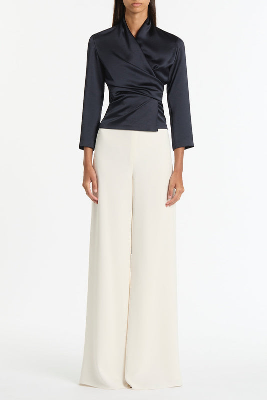 Image of a model wearing Tops. Product name - Ink Satin Wrap Top in Navy colour by brand - Carla Zampatti