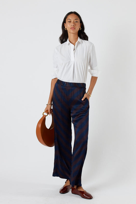 Image of a model wearing Pants. Product name - Itami Stripe Pant Navy in Navy colour by brand - Itami Division