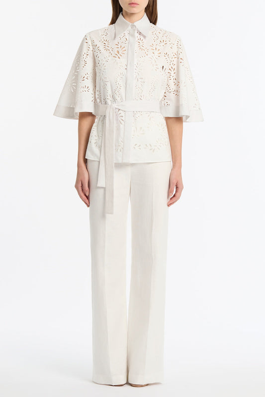 Image of a model wearing Tops. Product name - Ivory Lace Broderie Fluted Sleeve Tie Top in Ivory colour by brand - Carla Zampatti