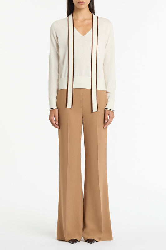 Image of a model wearing Tops. Product name - Ivory Merino Tipped Tie Neck Knit Top in White colour by brand - Carla Zampatti