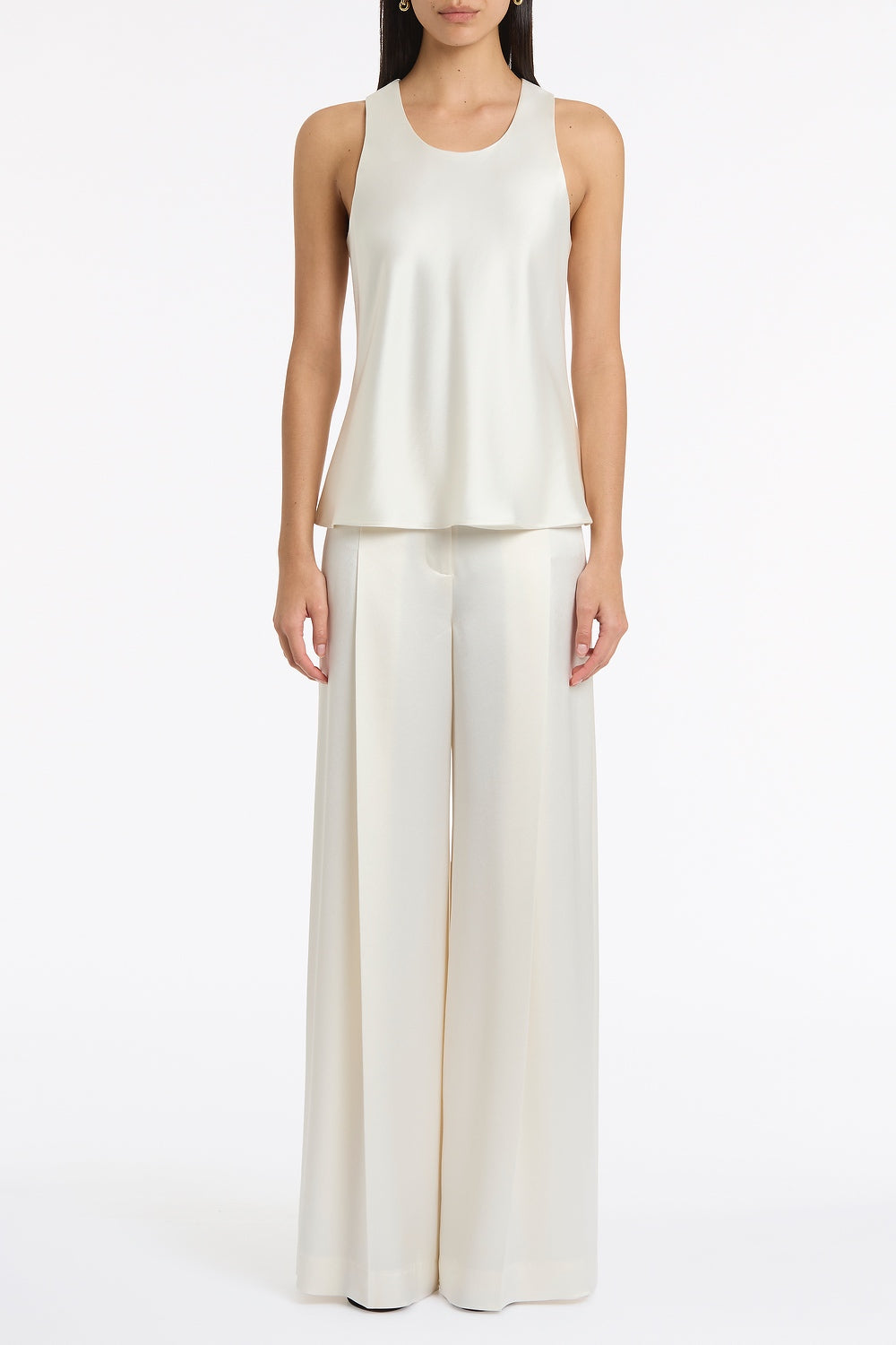 Image of a model wearing Tops. Product name - Ivory Satin Acetate Racer Tank in Ivory colour by brand - Carla Zampatti