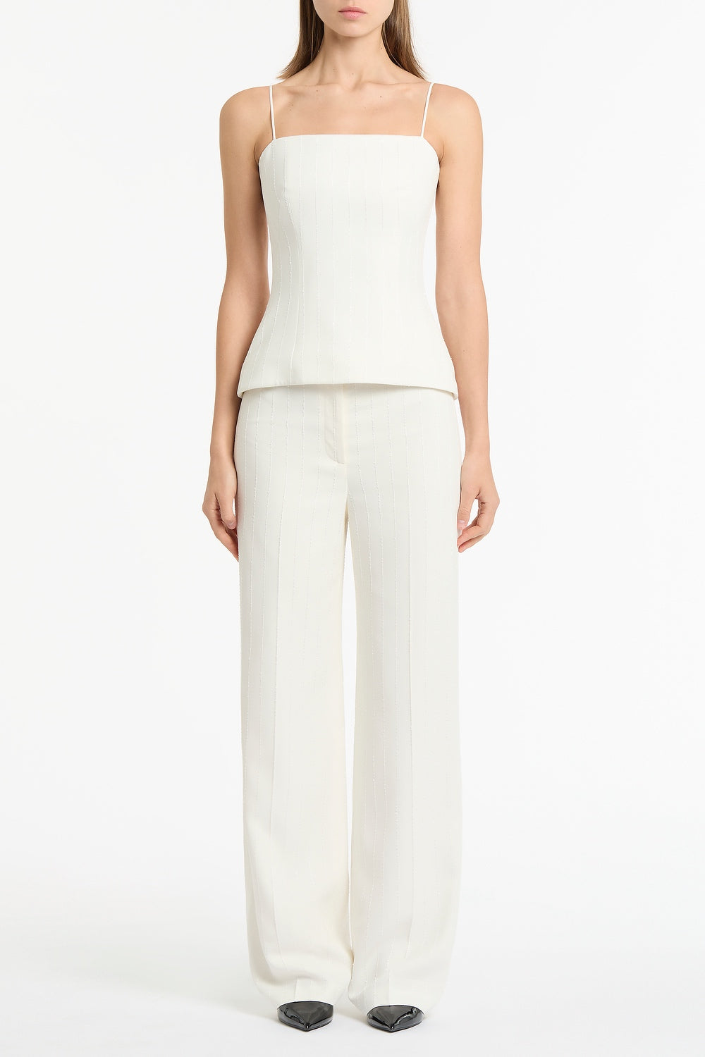 Image of a model wearing Pants. Product name - Ivory Starlight Twill Tuck Front Pant in White colour by brand - Carla Zampatti
