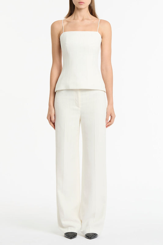 Image of a model wearing Pants. Product name - Ivory Starlight Twill Tuck Front Pant in White colour by brand - Carla Zampatti
