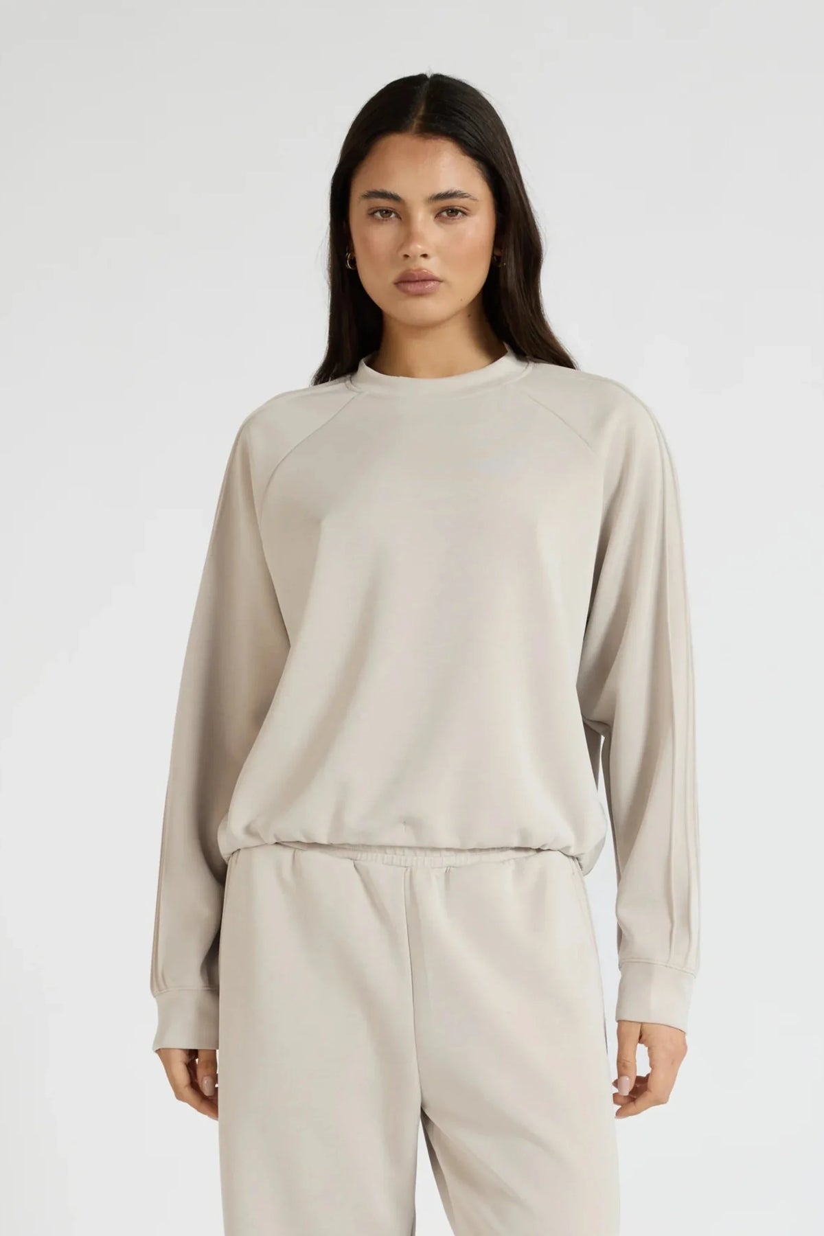 Image of a model wearing Outerwear. Product name - Soft Luxury Raglan Crew Jumper in Stone colour by brand - All Fenix