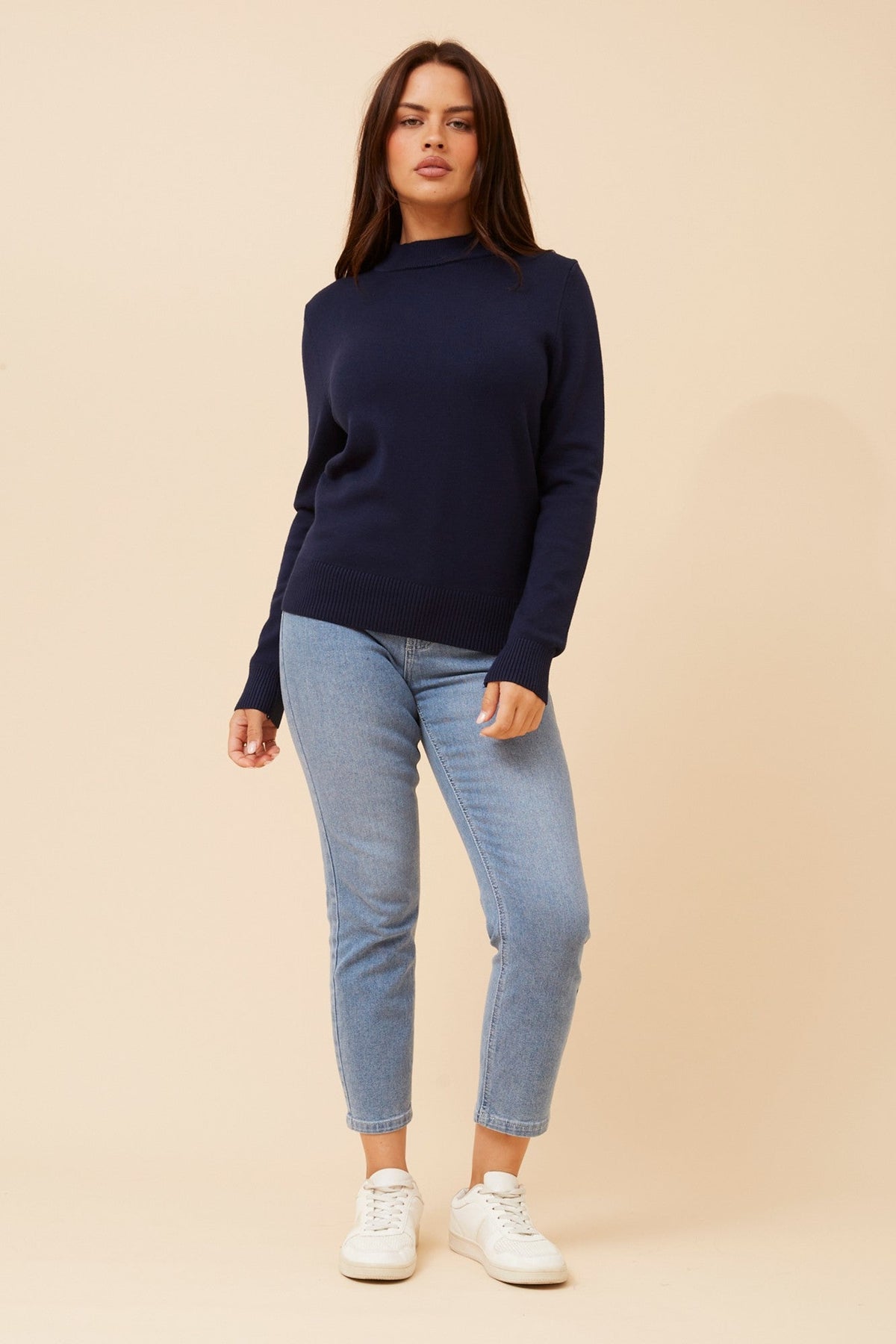 Image of a model wearing Tops. Product name - PETUNIA TURTLE NECK KNIT PULLOVER in Navy colour by brand - Caroline Morgan Australia