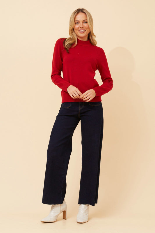 Image of a model wearing Tops. Product name - PETUNIA TURTLE NECK KNIT PULLOVER in Rich Red colour by brand - Caroline Morgan Australia