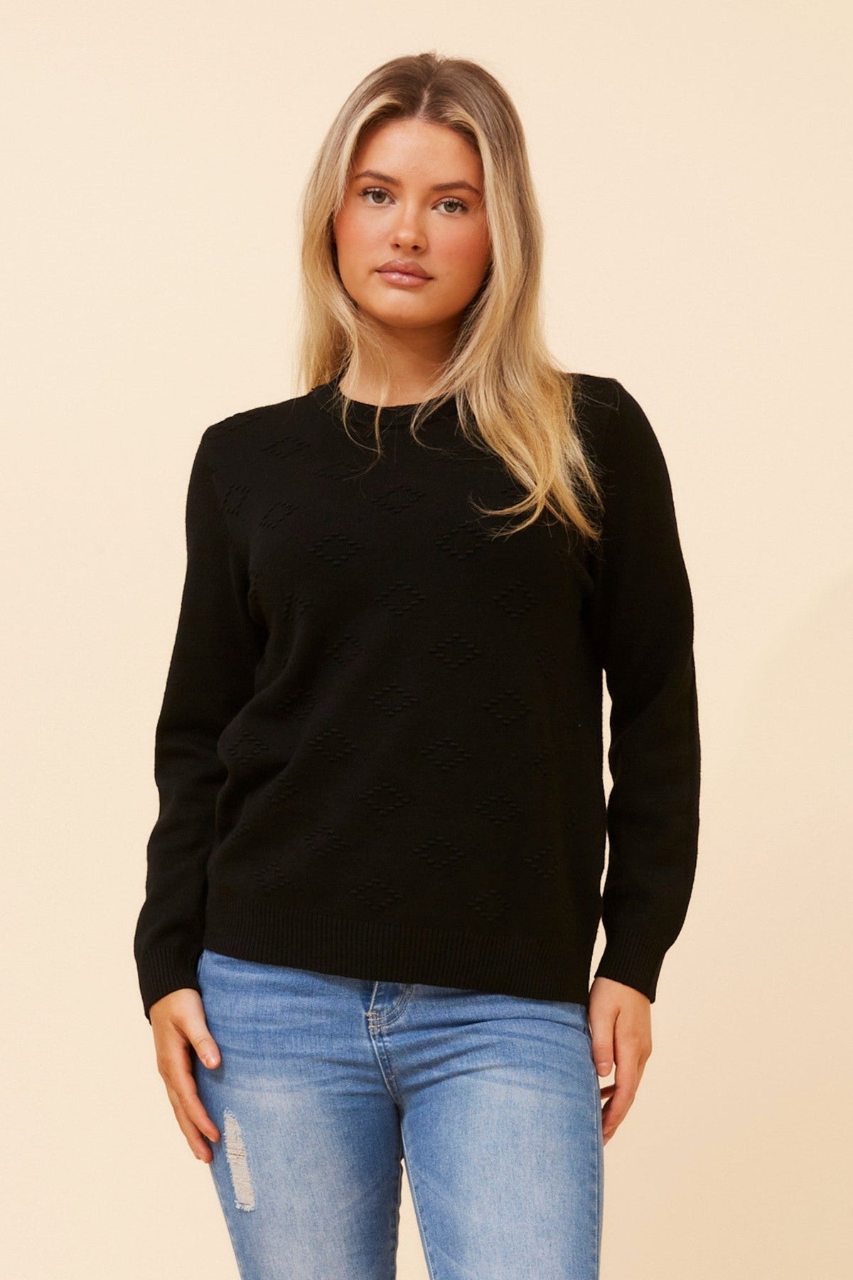 Image of a model wearing Outerwear. Product name - ANGIE DIAMOND PATTERN KNIT PULLOVER in Black colour by brand - Caroline Morgan Australia