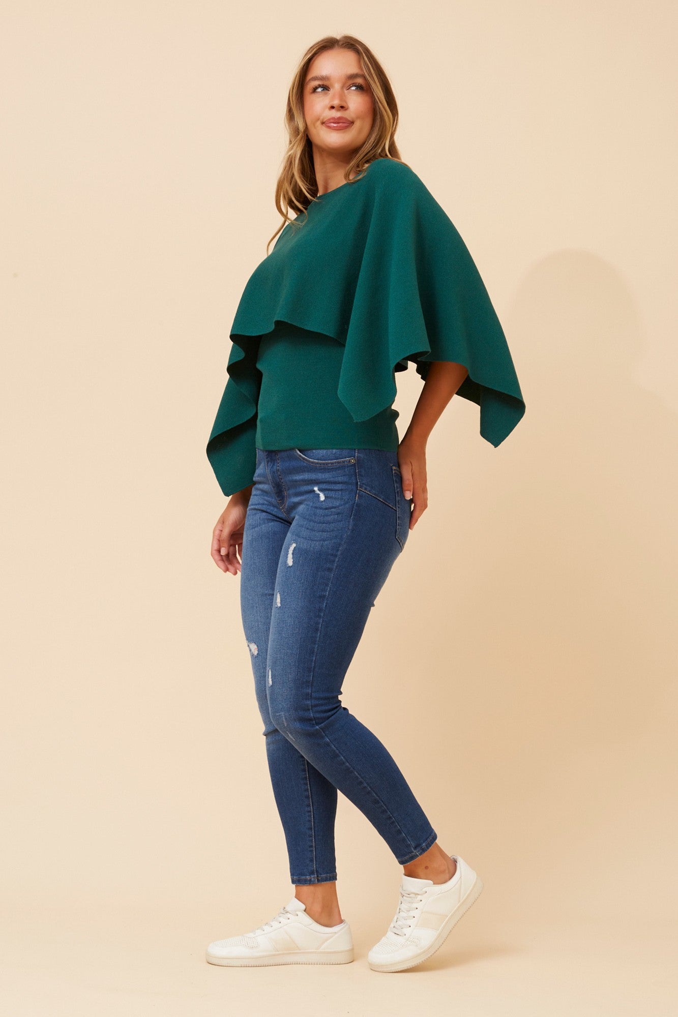 Image of a model wearing Outerwear. Product name - CLARETTA DOUBLE LAYERED KNIT PULLOVER in Emerald colour by brand - Caroline Morgan Australia