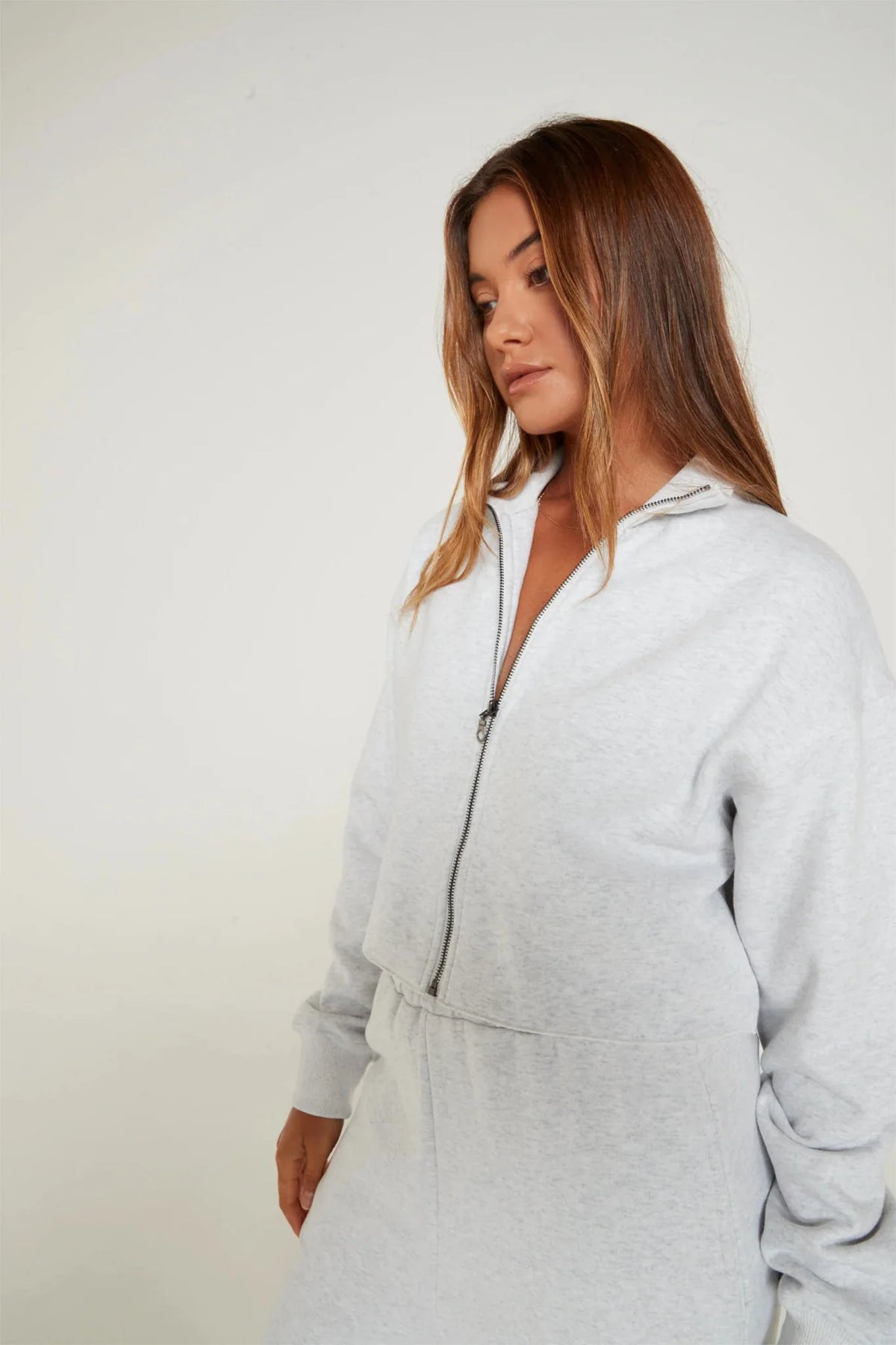 Image of a model wearing Outerwear. Product name - Lily Full Zip Sweater in White colour by brand - All Fenix