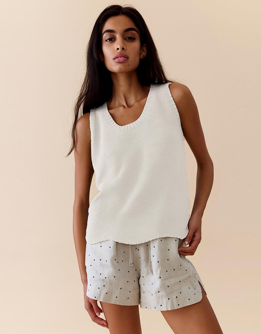 Image of a model wearing Outerwear. Productname: Scallop Hem Tank - in White colour by brand - Little Lies
