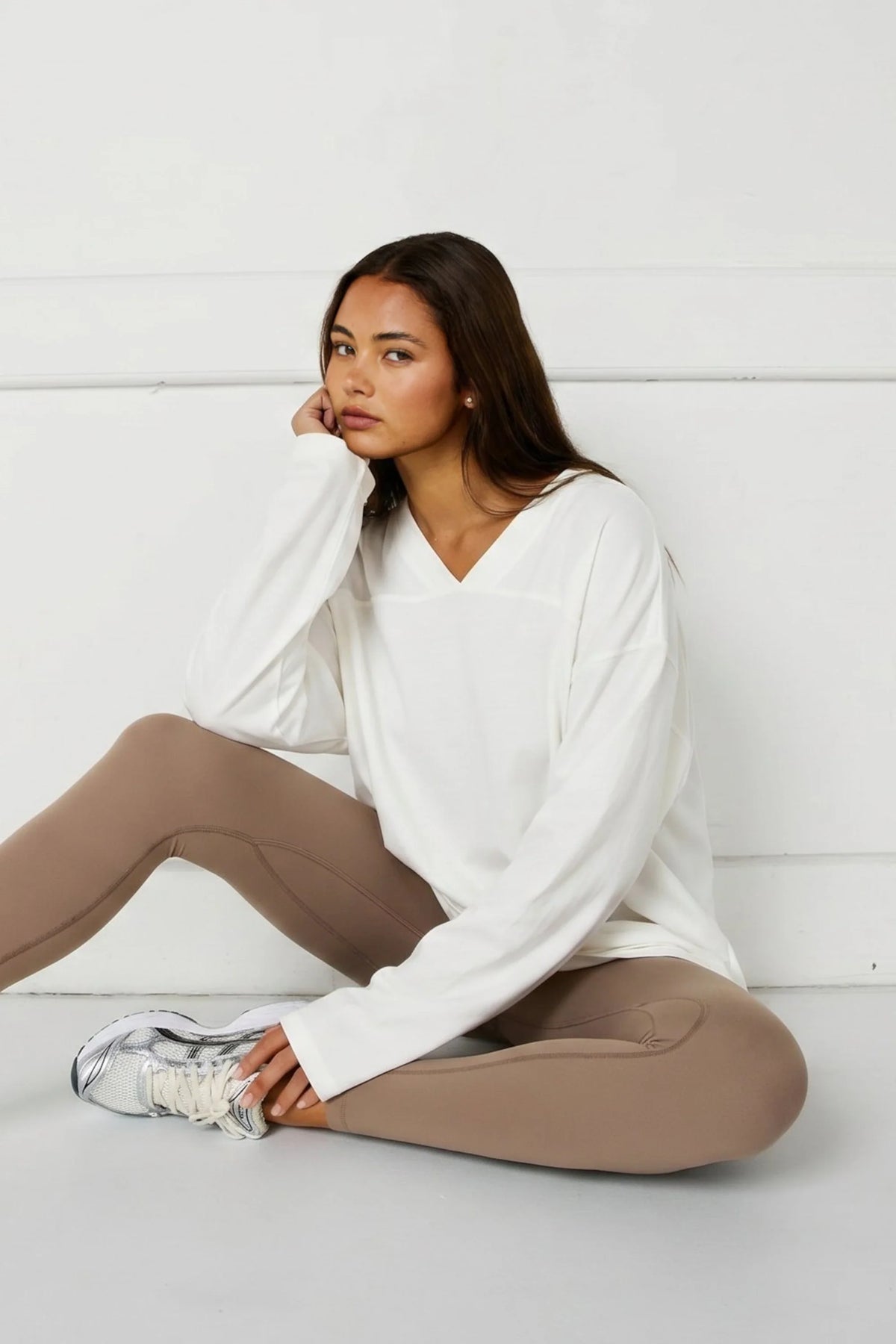Image of a model wearing Tops. Product name - Oversized V-Neck Long Sleeve in Chalk colour by brand - All Fenix