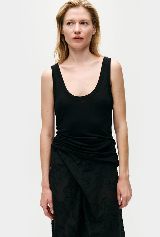 Image of a model wearing Tops. Product name - Jersey Modal Scoop Tank Black in Black colour by brand - Silk Laundry