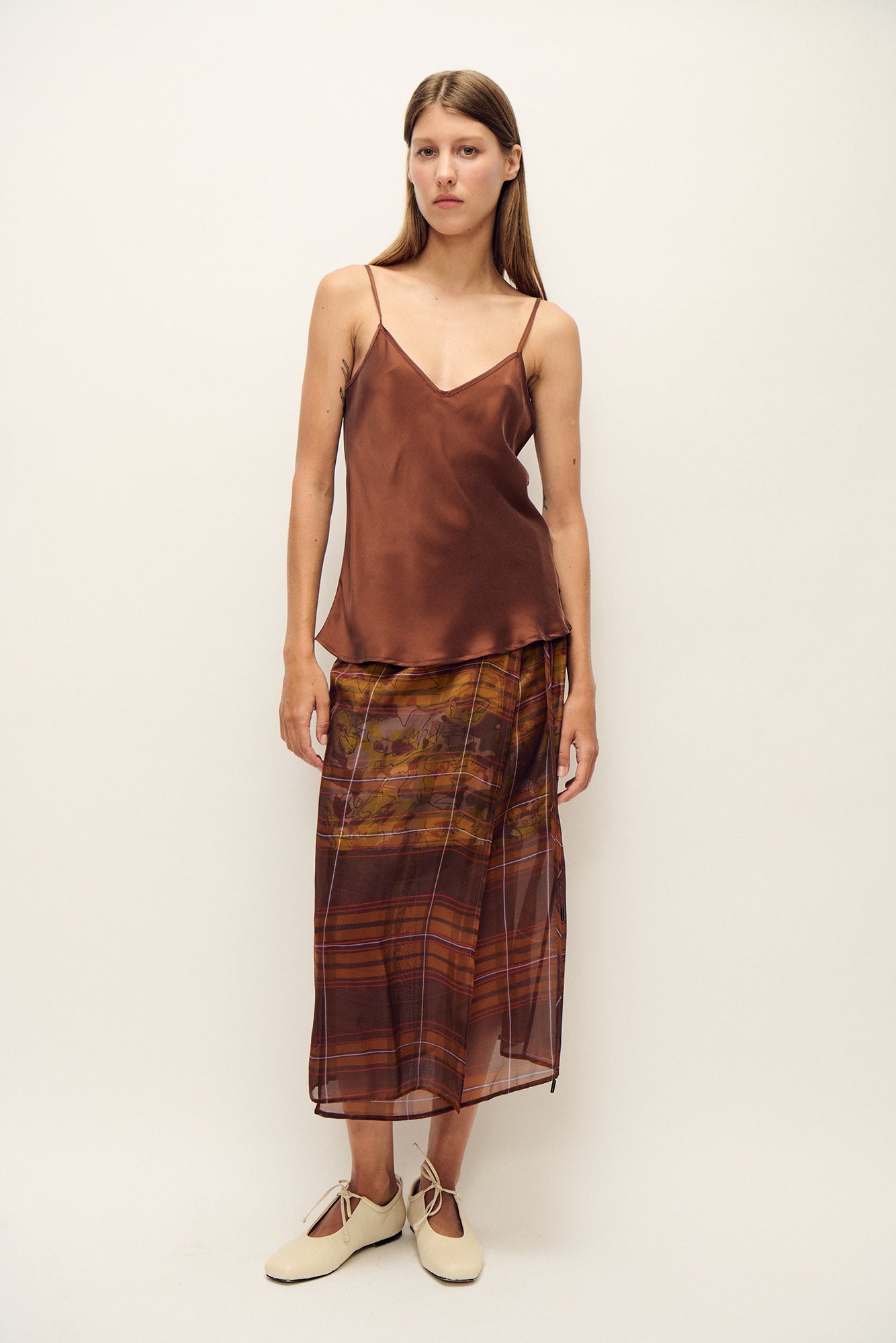 Image of a model wearing Tops. Product name - Bias Cut Cami Root in Root colour by brand - Silk Laundry