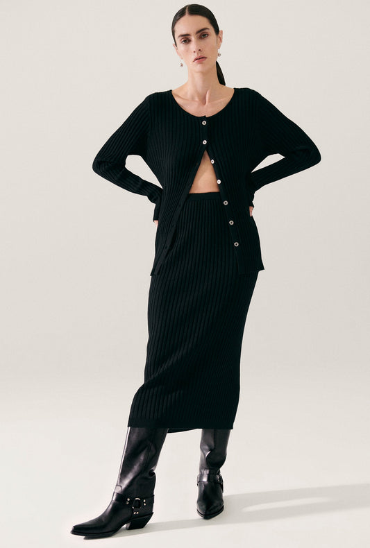 Image of a model wearing Skirts. Productname: Ribbed Straight Skirt Black in Black colour by brand - Silk Laundry