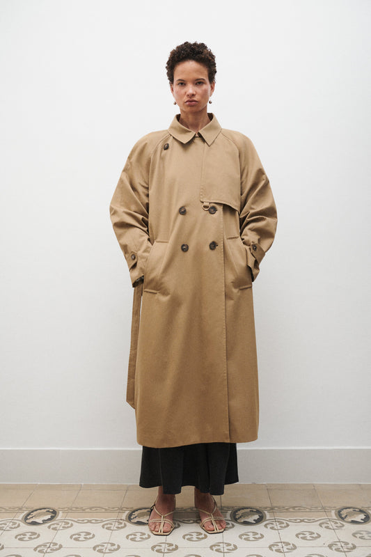 Image of a model wearing Outerwear. Product name - The Trench in Tan colour by brand - Silk Laundry
