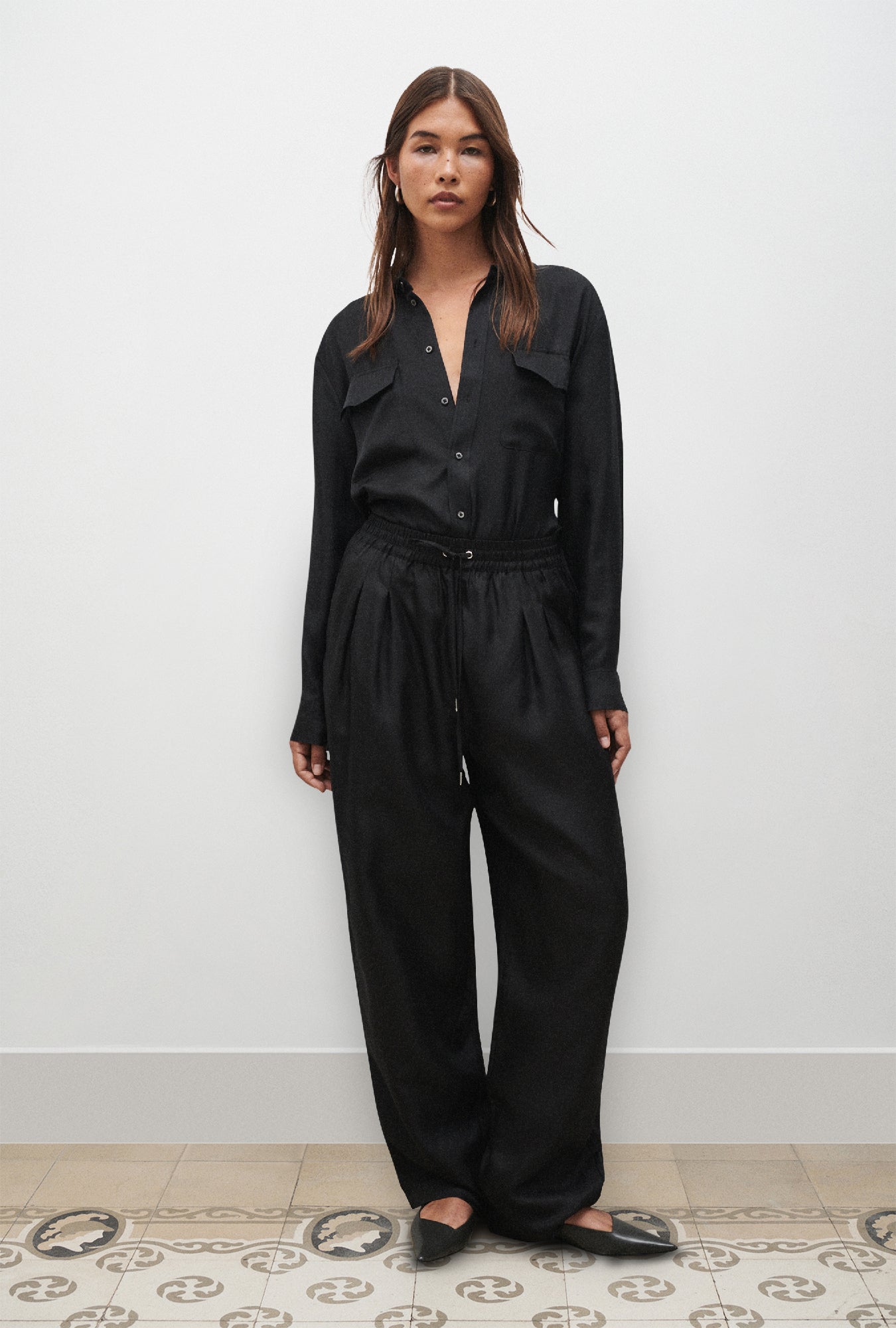 Image of a model wearing Pants. Product name - Twill Slouch Pants Black in Black colour by brand - Silk Laundry
