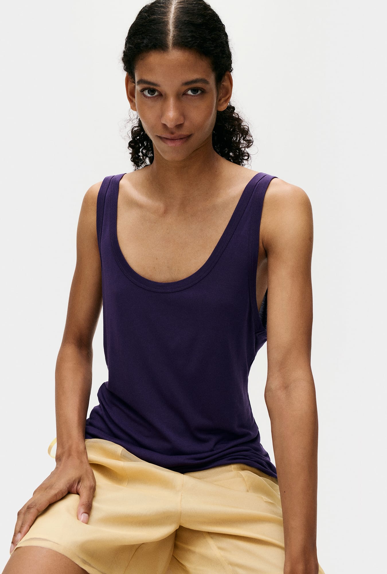 Image of a model wearing Tops. Product name - Jersey Modal Scoop Tank Nightshade in Nightshade colour by brand - Silk Laundry
